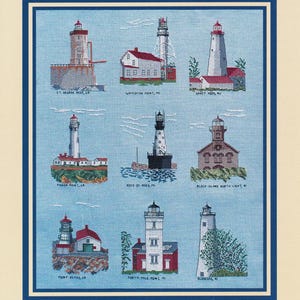 May include: A cross-stitch embroidery on light blue fabric featuring nine distinct lighthouses labelled St. George Reef, CA; Whitefish Point, MI; Sandy Hook, NJ; Pigeon Point, CA; Rock of Ages, MI; Block Island North Light, RI; Point Reyes, CA; Forty Mile Point, MI; and Ocracoke, NC.