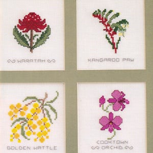 Può includere: Quattro motivi a punto croce su tessuto bianco raffiguranti flora australiana. In alto a sinistra: Waratah rossa. In alto a destra: zampa di canguro verde e rossa. In basso a sinistra: acacia dorata. In basso a destra: orchidea Cooktown viola.