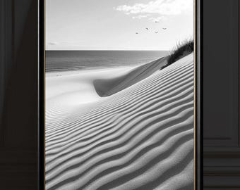 Puede incluir: Impresión enmarcada en blanco y negro de una escena de playa. La imagen presenta una duna de arena con texturas onduladas, el mar y un cielo despejado con algunos pájaros. El marco es negro con un borde interior dorado.