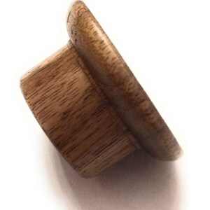 May include: A wooden finial with a rounded top and a slightly flared base. The finial is a light brown colour and has a natural wood grain.