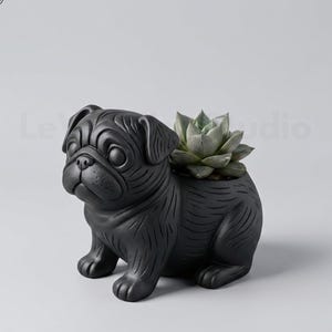 May include: A matte black ceramic planter shaped like a sitting pug dog. The planter features detailed etched lines representing fur and facial features. A green succulent plant is nestled in the opening on the back of the pug figure.