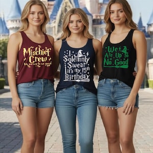 May include: Three women wearing tank tops with text. The first tank top is maroon with gold text that reads "Mischief Crew". The second tank top is navy blue with white text that reads "I Solemnly Swear it's my 15th Birthday". The third tank top is black with green text that reads "We Are Up to No Good".