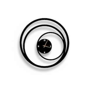 以下が含まれることがあります： ユニークなスパイラルデザインの黒い壁掛け時計。時計の文字盤は黒で、金の針と白い数字が付いています。時計の外側のデザインは、3つの同心円の黒い円で構成されており、モダンでミニマリストな美学を作り出しています。