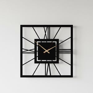 May include: A square black wall clock with a minimalist design. The clock features a black square face with gold-colored hands and Roman numerals. The clock's frame is also black, with linear accents radiating from the center.