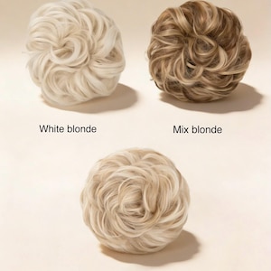 May include: Three hair bun extensions in white blonde, mix blonde, and light blonde. Each bun is a tightly wound, voluminous style. The text "White blonde", "Mix blonde", and "Light blonde" are below each bun.