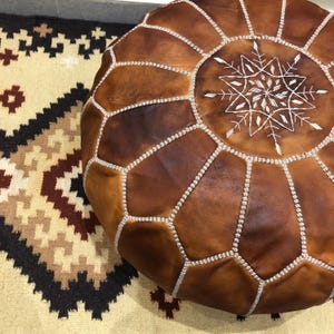 Leather pouf styled in a boho living room.