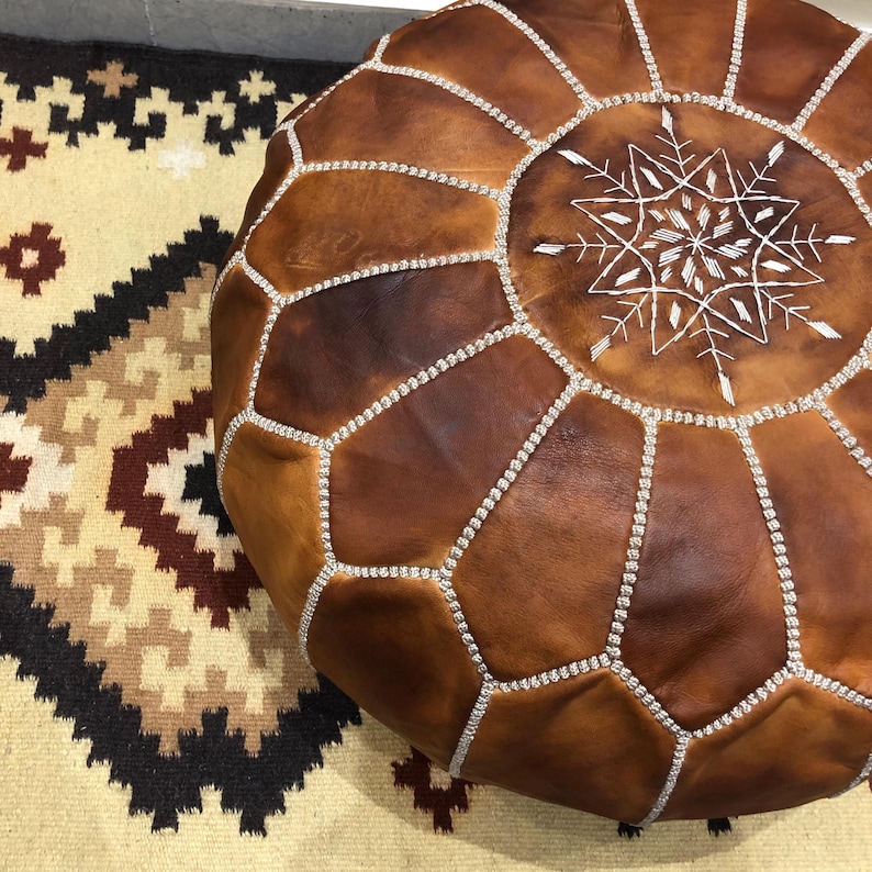 Leather pouf styled in a boho living room.