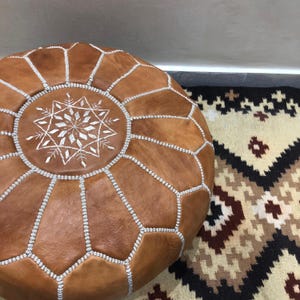Brown Moroccan pouf used as a footrest.
