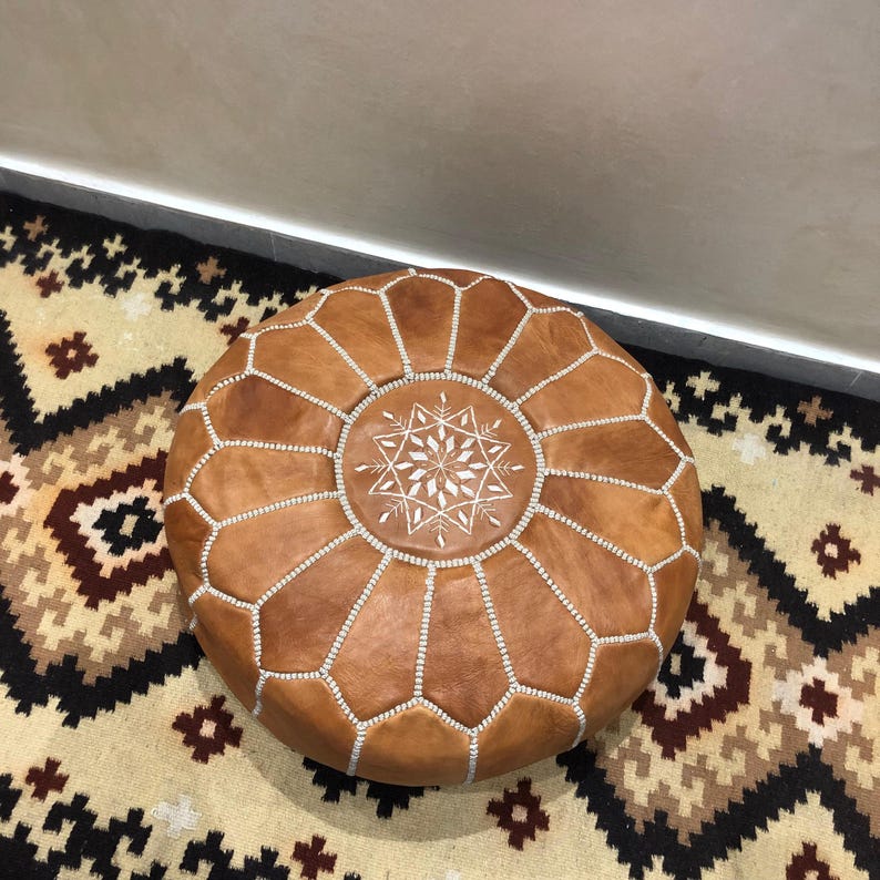Handmade Moroccan leather pouf in a modern living room.