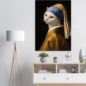 Peut inclure: Impression sur toile encadrée représentant un chat blanc portant un foulard bleu et une robe dorée, rappelant le tableau "La Jeune Fille à la perle". Le chat a les yeux jaunes et une boucle d'oreille en perle.