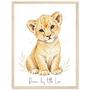 Puede incluir: Un estampado enmarcado de acuarela de un lindo cachorro de león. El cachorro está sentado y mirando al espectador con una ligera sonrisa. El estampado tiene un fondo beige claro con el texto "Dream big, little Lion" en escritura marrón.