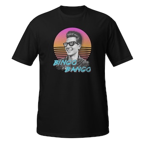 May include: Black t-shirt with a retro graphic of a person wearing sunglasses, set against a sunset design. The text "BINGO BANGO" is displayed below the image. The shirt is a classic crew neck style.