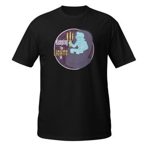 May include: A black short-sleeve t-shirt featuring a circular graphic of a light blue skeleton figure wearing sunglasses, sitting in a dark purple chair while holding a lit candelabra. The text "Keeping The LIGHTS ON" is printed in white and yellow.