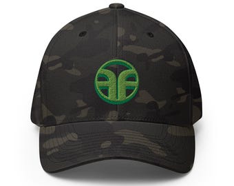 Puede incluir: Una gorra de béisbol con estampado de camuflaje en negro y gris oscuro que presenta un logotipo circular bordado en verde brillante en el panel frontal. La gorra tiene una corona estructurada, una visera curva y un botón en el centro superior.