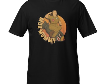 Puede incluir: Camiseta negra con una ilustración de dibujos animados de una persona con un traje de vuelo montada en una bomba. El diseño incluye el texto "MOD-MOMMY". La bomba tiene una boca de tiburón.