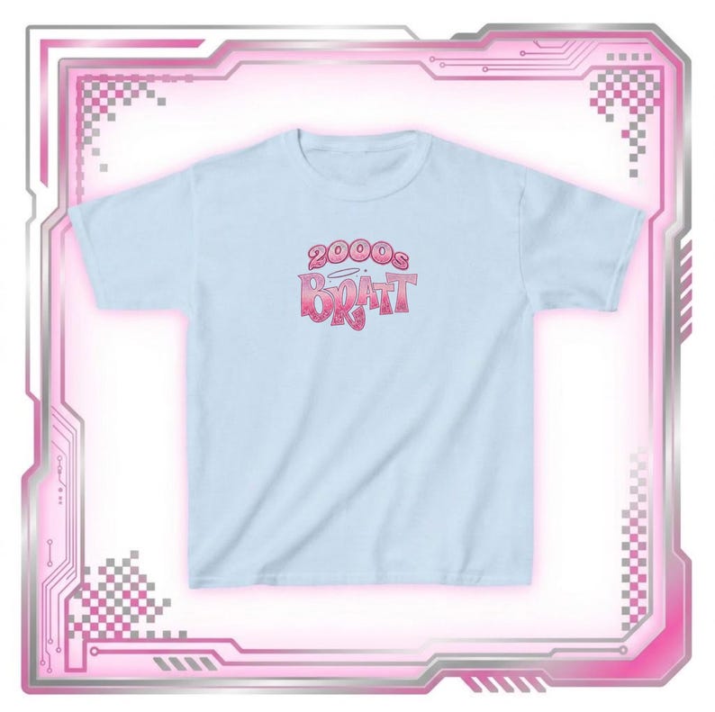 May include: A light blue t-shirt with the text "2000s Bratt" in a pink gradient font. The shirt has short sleeves and a crew neck. The design is centered on the front of the shirt.