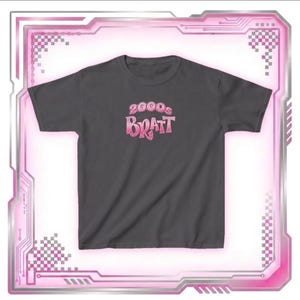 May include: Dark gray t-shirt with the text "2000s Bratt" in a pink gradient font. The shirt has a crew neck and short sleeves. The design is centered on the chest.