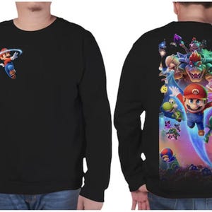 Puede incluir: Sudadera negra de manga larga con un peque&ntilde;o gr&aacute;fico de Mario en la parte delantera y un gr&aacute;fico grande y colorido de Mario y otros personajes en la parte trasera. El gr&aacute;fico incluye a Mario, Bowser, la Princesa Peach y Yoshi.