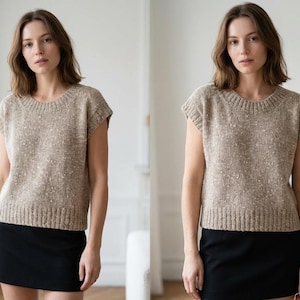 May include: A beige knit top with a round neckline and short sleeves. The top has a textured appearance with flecks of white. The model is wearing a black skirt. The top is a versatile piece for casual wear.