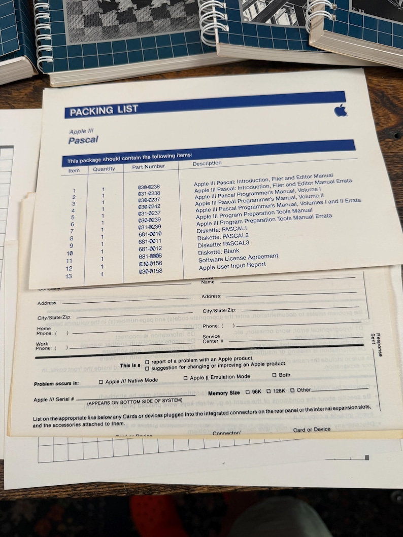 Puede incluir: Un documento de lista de empaque Apple III Pascal blanco que presenta una tabla de trece art&iacute;culos, incluyendo manuales y disquetes, con un formulario de informe de usuario debajo. El documento incluye el logotipo de Apple y n&uacute;meros de parte.