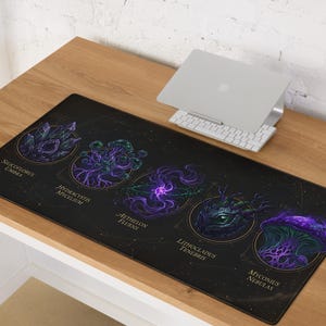 May include: Black desk mat featuring fantasy illustrations of crystals and mushrooms in purple and green. The mat has text labels including "Siliciflorus Umbra" and "Hydracystis Mycelium". A laptop and keyboard rest on the desk.