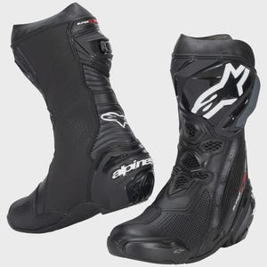 May include: Pair of black motorcycle boots. The boots have a tall design, with reinforced areas on the shin and ankle. The boots feature the brand name "Alpine" and the text "Supertech R". White and gray accents are visible.