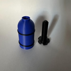 May include: A blue cylindrical object with two black bands and a black screw. The cylindrical object has a rounded top and a narrow opening. The screw has a star-shaped base.
