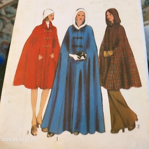 May include: A sewing pattern illustration featuring three distinct cape designs. The first is a knee-length red cape with toggle closures. The second is a full-length blue cape with a fur-trimmed hood. The third is a plaid hooded cape.