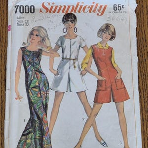 Op de afbeelding: Een vintage Simplicity 7000 naaipatroon-envelop voor maat 12, buste 32. De voorzijde toont illustraties van drie outfits: een lange jurk met patroon, een witte romper en een oranje romper met een geel overhemd, gelabeld als Simple-to-Sew.