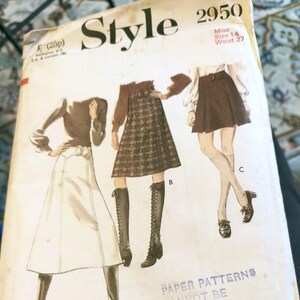 May include: Vintage sewing pattern titled "Style 2950". The cover features illustrations of three different skirt and top outfits. The pattern includes measurements for Miss Size 14 and a 27-inch waist. The cover is aged with visible wear.
