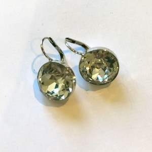 Orecchini in argento punzonato con grande pietra di pasta bianca. Rotondi da 1/2"
