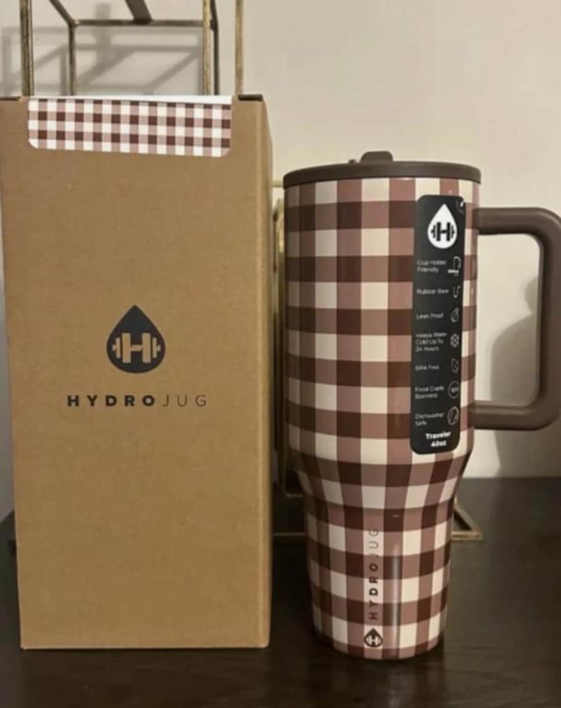 May include: A brown and white checkered Hydrojug tumbler with a handle and a matching box. The tumbler has a brown lid and handle. The box has the Hydrojug logo and text. The tumbler is designed to hold 40oz.