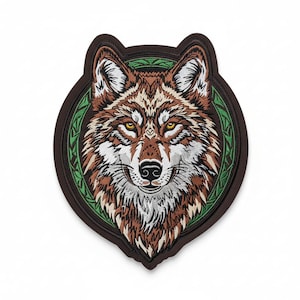 May include: Embroidered patch featuring a detailed wolf head design. The wolf has brown and white fur, yellow eyes, and a black nose. The patch is framed by a green and brown border, creating a striking emblem.
