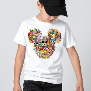 Puede incluir: Camiseta blanca con un colorido collage de personajes de Disney que forman la cabeza de Mickey Mouse. El dise&ntilde;o incluye personajes como Mickey, Donald y Goofy. La camiseta la lleva una persona con una gorra de b&eacute;isbol negra.
