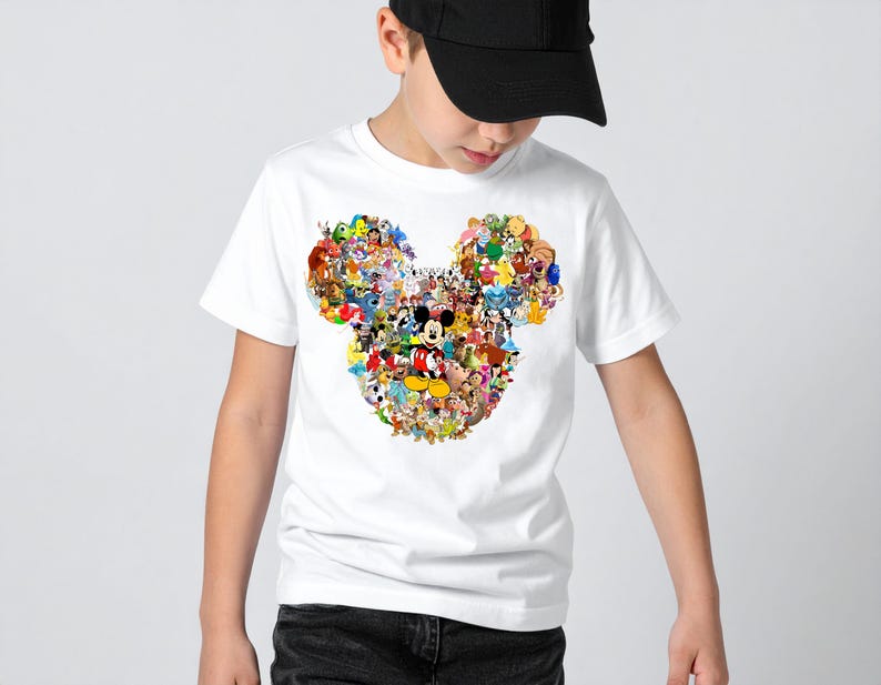 Puede incluir: Camiseta blanca con un colorido collage de personajes de Disney que forman la cabeza de Mickey Mouse. El dise&ntilde;o incluye personajes como Mickey, Donald y Goofy. La camiseta la lleva una persona con una gorra de b&eacute;isbol negra.