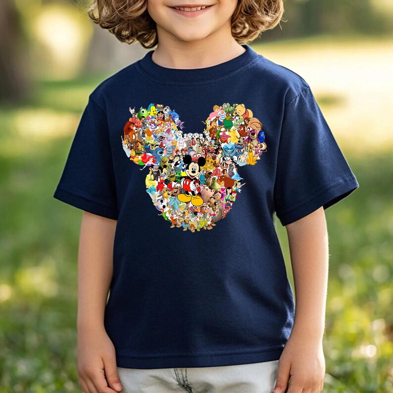 Puede incluir: Camiseta azul marino con un dise&ntilde;o de cabeza de Mickey Mouse lleno de personajes de Disney. El gr&aacute;fico colorido incluye a Mickey Mouse, Minnie Mouse, Donald Duck y otros personajes. La camiseta es de material suave, para ni&ntilde;os.