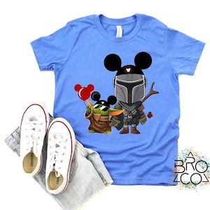 May include: A white ceramic mug with a black handle and the text "But First, Coffee" in a bold, black font. The mug is set against a blurred background, highlighting its clean design.