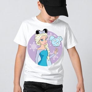 May include: White t-shirt featuring a cartoon illustration of Elsa from Frozen, wearing a bow and holding a cotton candy shaped like Mickey Mouse ears. The design is set against a purple background with star accents.