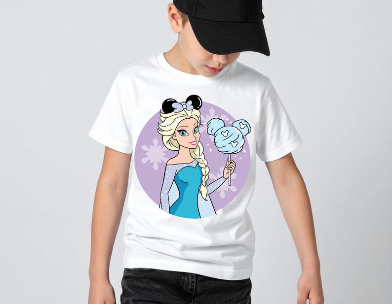 May include: White t-shirt featuring a cartoon illustration of Elsa from Frozen, wearing a bow and holding a cotton candy shaped like Mickey Mouse ears. The design is set against a purple background with star accents.