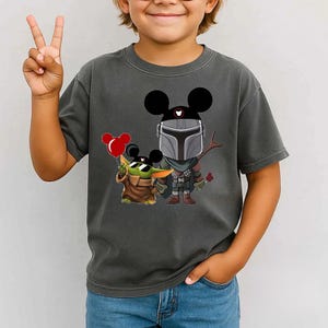 May include: A white ceramic mug with a black handle and the text "But First, Coffee" in a bold, black font. The mug is set against a blurred background, suggesting a cozy setting.