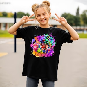 Puede incluir: Una camiseta negra de manga corta con un estampado gr&aacute;fico colorido de varios personajes de videojuegos, incluyendo a Mario, Yoshi y Bowser. El dise&ntilde;o incluye un n&uacute;mero 5 grande y el nombre SOPHIA en letras llamativas y multicolores.