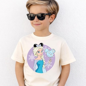 May include: A white ceramic mug with a black handle and the text "But First, Coffee" in a black, bold font. The mug is on a white surface.