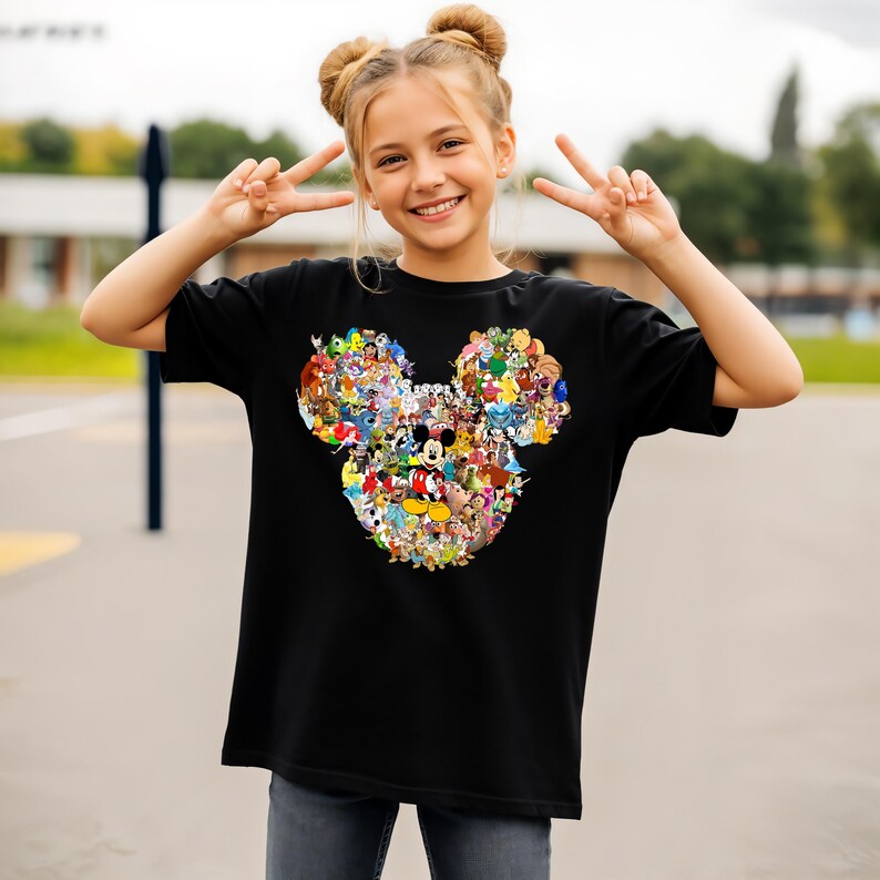 Puede incluir: Camiseta negra con un dise&ntilde;o colorido de la cabeza de Mickey Mouse compuesto por varios personajes de Disney. El dise&ntilde;o incluye a Mickey, Minnie, Donald y Goofy. La camiseta est&aacute; hecha de un material suave.