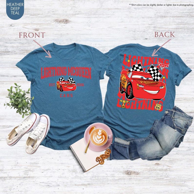 May include: Teal t-shirts featuring Lightning McQueen from the Cars movie. The front of the shirt displays Lightning McQueen with the text "Lightning McQueen" and "Cars". The back of the shirt shows Lightning McQueen with checkered flags and the text "Lightning McQueen".
