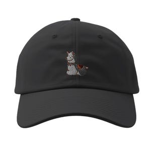 May include: Black baseball cap with a curved brim. The cap features an embroidered design of a dog wearing a bow tie and a vest. The dog is primarily gray and white with red and brown accents.