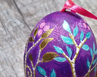 Purple & gold Easter egg. Painted eggshell ornament, painted with a stylised pattern of leaves and berries.