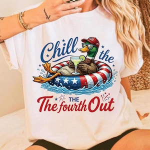 Könnte beinhalten: Weißes T-Shirt mit einer Cartoon-Ente, die eine Sonnenbrille und einen roten Hut trägt und in einem patriotischen Schwimmer mit einem Cocktail entspannt. Das Shirt trägt den Text "Chill the Fourth Out" in Blau und Rot.