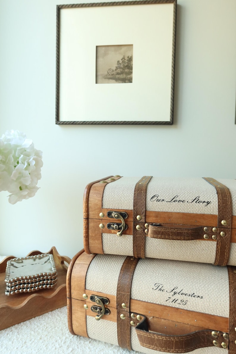 Custom memory trunk set with vintage suitcase styling, including cream canvas keepsake boxes with wood trim and leather accents. Elegant wedding keepsake storage for bridal shower gifts, couples’ memory boxes, engagement decor, and sentimental photo storage.