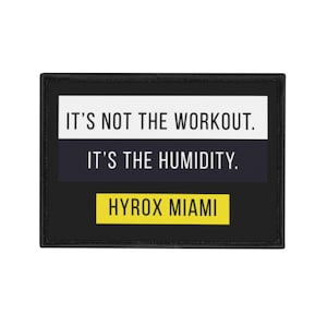 May include: Black rectangular patch with the text "IT'S NOT THE WORKOUT. IT'S THE HUMIDITY." in white text on a white and navy blue background. The bottom section has "HYROX MIAMI" in yellow text.