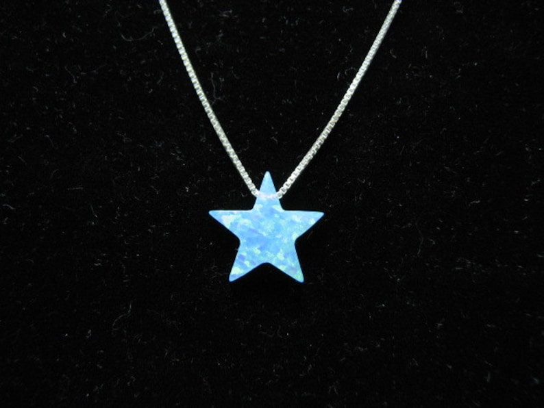 May include: A silver chain necklace with a blue opal star pendant.